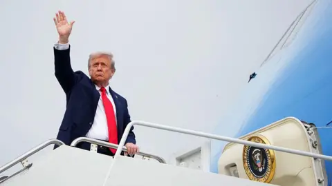 Getty Images El presidente de los Estados Unidos, Donald Trump, saluda mientras aborda la Fuerza Aérea One para partir de la base conjunta Elmendorf-Richardson 