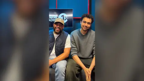 Richie Brave and Archie Madekwe smiling sitting next to each other in the 1Xtra studio