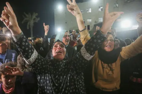 Getty Images Palestinians celebrate the announcement of a ceasefire agreement in Deir al-Balah in the central Gaza Strip.