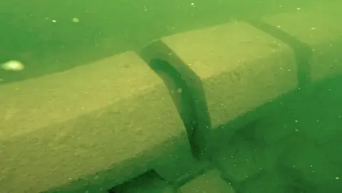 An underwater image of a sewage discharge pipe in Windermere