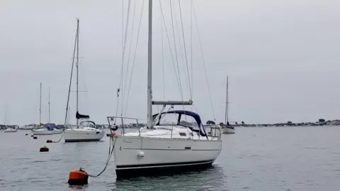 A sailing boat attached to a buoy in the harbour