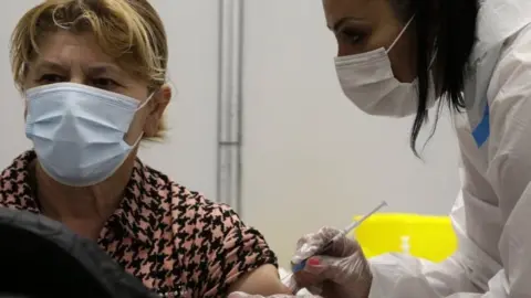 EPA A woman gets a Covid-10 vaccine in Belgrade, Serbia. File photo