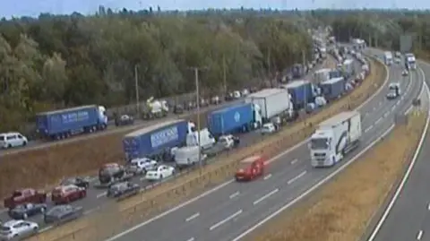National Highways A still from a traffic camera showing large queues of cars and lorries on the A14.