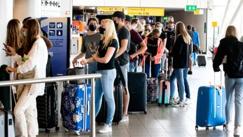 Getty Images Line of passengers inside Schiphol Airport