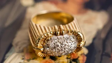 Bearnes Hampton & Littlewood An 18ct gold diamond ring, the domed white metal centrepiece is pavé set with twenty-seven single-cut diamonds of slightly varying size.