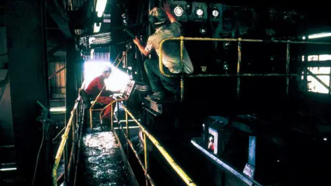 Getty Images Two men working on machinery inside Shirebrook Colliery in Derbyshire in 1993 months before it closed.