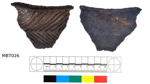 Daniel Brown The piece of pottery is v-shaped and brown in colour with rows of raised lines on it.