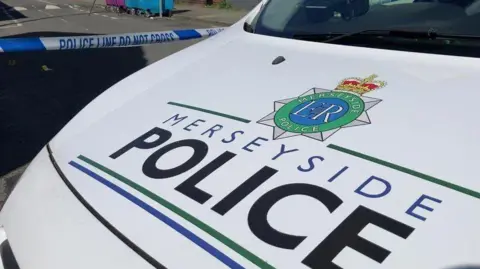 PA Media A white van with the Merseyside Police writing and logo