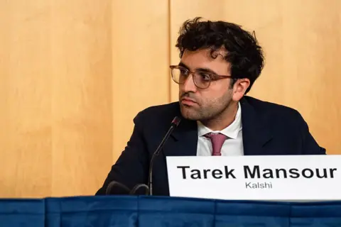 Bloomberg via Getty Images Tarek Mansour, co-founder of Kalshi, sits behind a mcirophone in a dark suit, with a white shirt and red tie during a joint SEC-CFTC roundtable at SEC headquarters in Washington, DC, US, on Monday, Sept. 29, 2025.