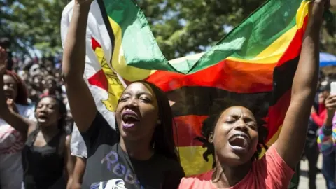 AFP Women holding a flag of Zimbabwe take part in a demonstration of University of Zimbabwe's students, on November 20, 2017 in Harare