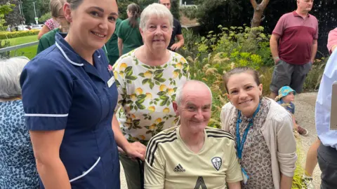 Stroke patient Kevin Doughty with family and staff members outside in the garden