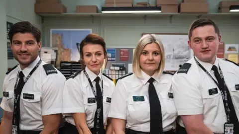 BBC/Long Story TV/Peter Marley Four actors from Hope Street. A man with dark hair and a beard, white shirt and black tie, a woman with brown hair a white blouse and dark tie, a woman with blonde hair a white blouse and black tie, and a man (Finnian Garbutt) with dark hair, wearing a white shirt and black tie.