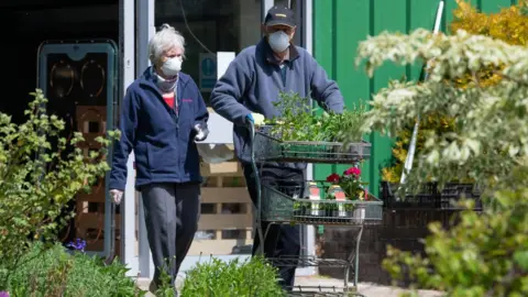 Getty Images Couple in masks at garden centre