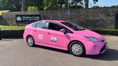 BBC/JULIA LEWIS Pink Taxi outside Skipton Castle