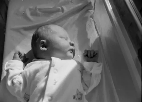 Francis Sanders Ester wearing a baby grow and sleeping shortly after her birth.