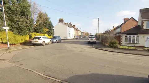 The view from Main Street to Chewton Street from Mr Brown's garage. The straight road bends towards the front right. Houses are on either side of the road.