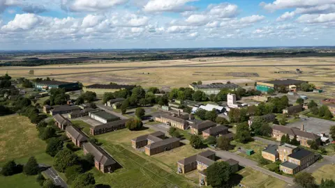 PA Media Aerial view of the Scampton base showing brick buildings in the foreground and the runway in the background