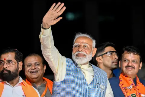 AFP India's Prime Minister and leader of the ruling Bharatiya Janata Party (BJP) Narendra Modi (C) with chief minister of Maharashtra state Eknath Shinde (L) and their deputy chief Minister Devendra Fadnavis (R) waves to the crowd during his roadshow in Mumbai on May 15, 2024, ahead of the fifth phase of voting of India's general electio