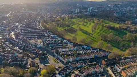 Getty Images Aerial view of Bristol showing the Clifton Downs surrounded by residential streets with closely packed, multi-coloured homes and brown rooftops.