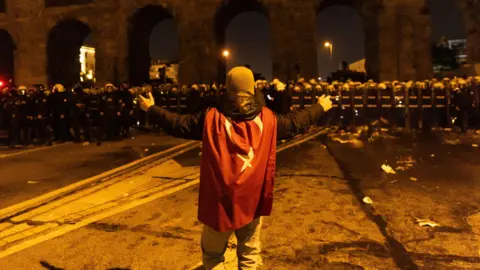 EPA A demonstrator stands in front of Turkish riot police during a protest against the detention of Istanbul Mayor Ekrem Imamoglu, in Istanbul, Turkey, 21 March 2025.