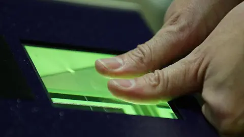 Getty Images Fingerprints are scanned via a green light.
