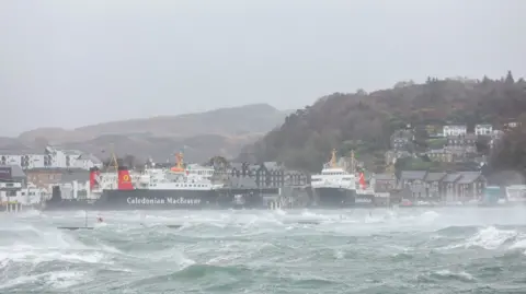 Reuters Two CalMac ferries are berthed in stormy waters at Oban harbour