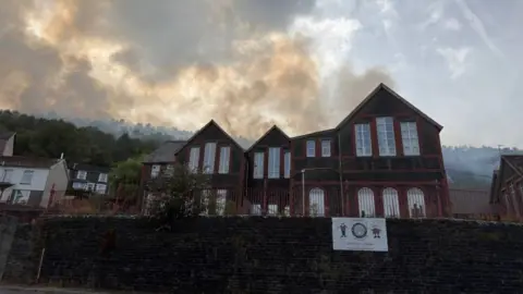 A fire seen behind some houses