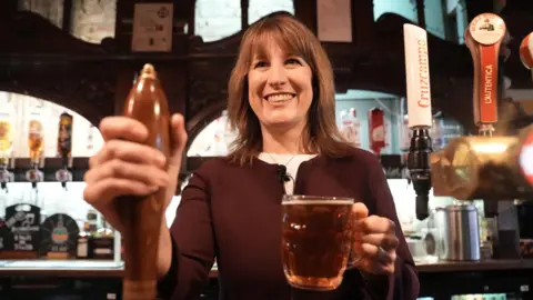 PA Media Chancellor Rachel Reeves pulls a pint at a pub