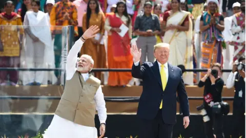 Getty Images Narendra Modi and Donald Trump wave to the crowd