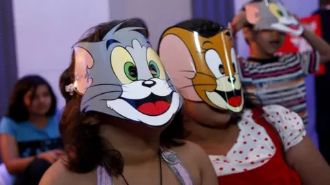 India Today via Getty Images Children in Tom and Jerry masks