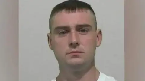 Mugshot of John Kirtley who is wearing a white T-shirt and has a short hair.