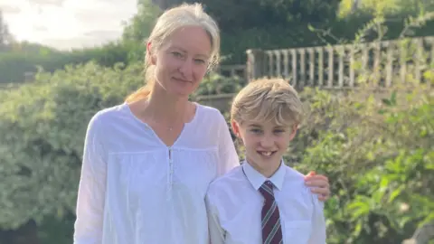 Maxi with his mum, Joanna stood in their garden