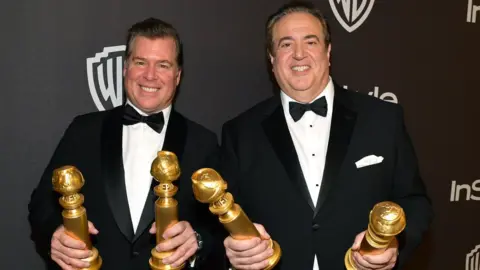 Getty Images Brian Currie (left) and Nick Vallelonga with their Golden Globes