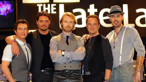 Getty Images 
DUBLIN, IRELAND - NOVEMBER 23: Boyzone members Stephen Gately, Keith Duffy, Ronan Keating, Mikey Graham and Shane Lynch attend RTE's The Late Late Show at RTE Studios on November 23, 2007 in Dublin, Ireland. (Photo by ShowBizIreland/Getty Images)