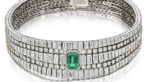 Met Police A three tiered diamond necklace with a large green sapphire in the centre. 