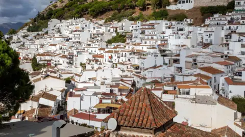 Getty Images A picture of Mijas taken from above. The town is made up of lots of white buildings with orange rooftops sprawling across a large hill.