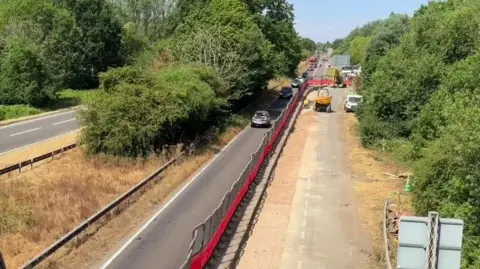 A lane closure on the A40. There is a big trench which has been dug in the closed lane.