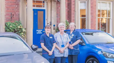 Beaumond House Hospice Care staff stood outside their headquarters, a large Victorian building in Newark