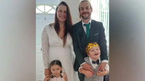 Family photograph David Wrag and his wife Sara are pictured in a family photo with their children by their sides, dressed in smart clothes and the son wearing a paper crown on his head