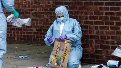 Getty Images Forensic worker seals up evidence in bag