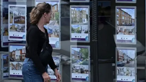 Woman looking in estate agent window