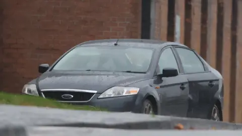 The grey Ford Mondeo in which the bomb was placed sits outside the Waterside Police Station in Londonderry