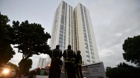 Reuters Firefighters outside a tower block