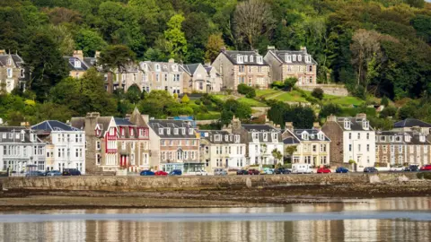 Getty Images A row of houses and shops on the sea front of a small town on an island