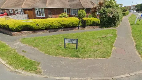 The corner of a residential street. There is a sign saying Lane End Road.