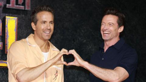 Ryan Reynolds and Hugh Jackman form a heart with their hands at the Deadpool premiere