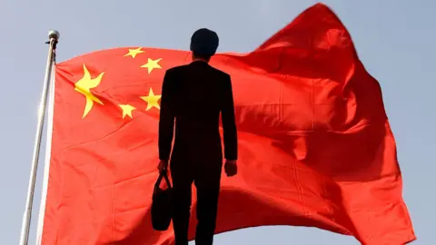 Getty Images Businessman against Chinese flag in double exposure.