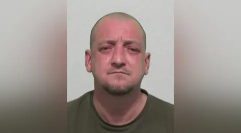 Northumbria Police Mugshot of a bald man with a short beard