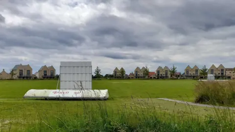 Local Democracy Reporting Service A playing field at Alconbury Weald, Huntingdon, with rows of semi-detached three-storey houses in the background