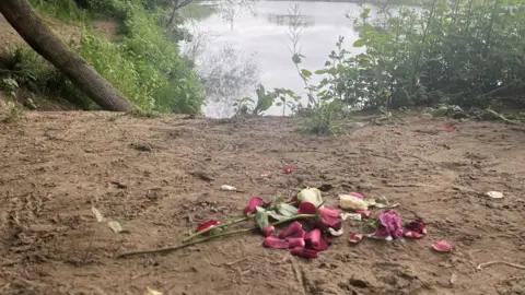 PA Red and white roses left by the Tyne